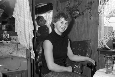811319 Portret van een vrouw in een woonwagen op het woonwagenkamp aan de Huppeldijk te Utrecht.